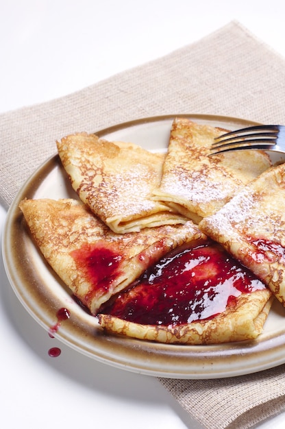 Pfannkuchen mit Kirschmarmelade auf dem Tisch