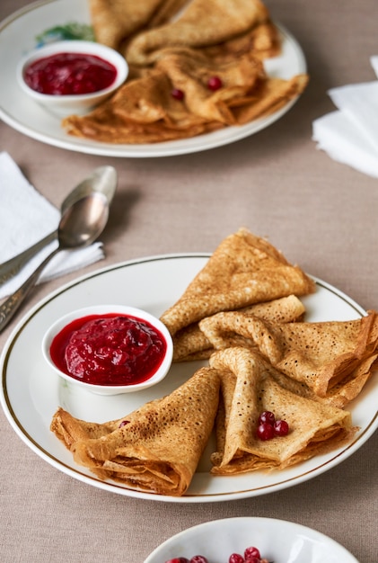 Pfannkuchen mit Preiselbeersauce auf einem weißen Teller