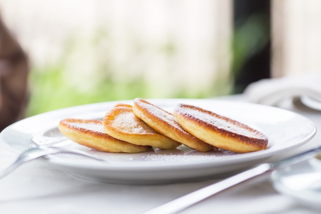 Pfannkuchen mit Puderzucker auf einer weißen Platte