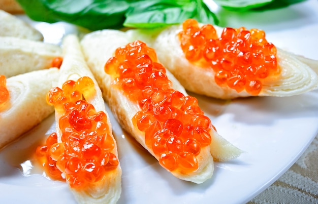 Pfannkuchen mit rotem Kaviar auf einem weißen Teller