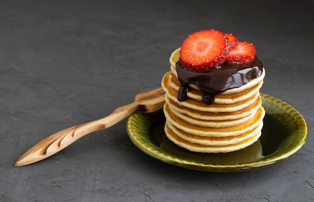 Pfannkuchen mit Schokolade auf einem grauen Hintergrund.