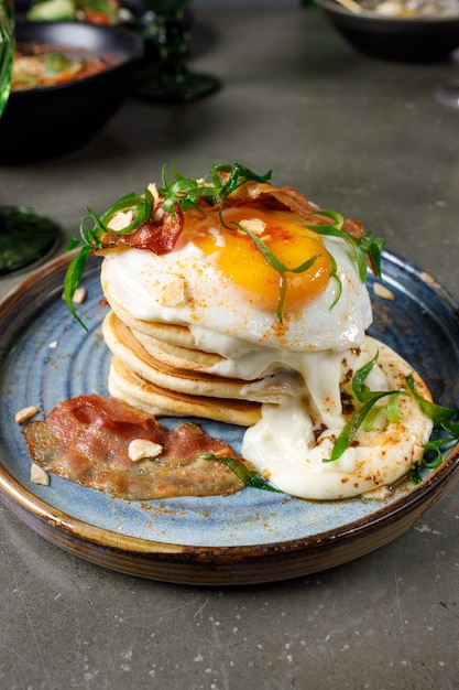 Pfannkuchen mit Speck, Spiegelei und geschmolzenem Käse