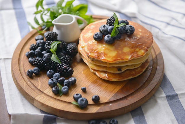 Pfannkuchen und Beeren auf dem Brett mit Honig - Draufsicht