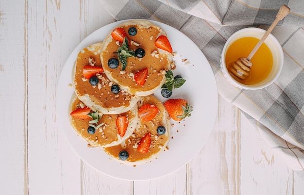 Pfannkuchenfrühstückskonzept mit Honig- und Nußbeeren