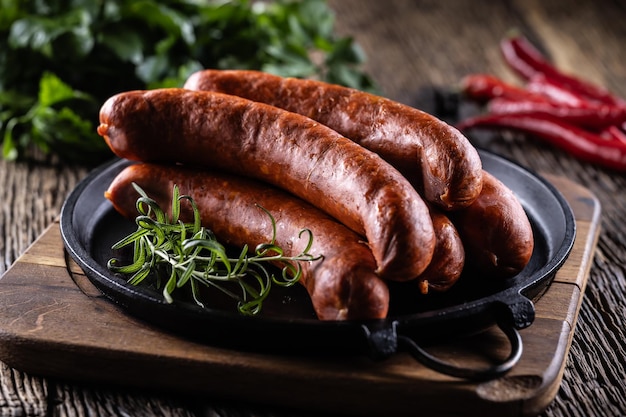 Pfeffer, Schweinefleisch, geräucherte Würstchen mit Rosmarin in einer Gusseisenpfanne