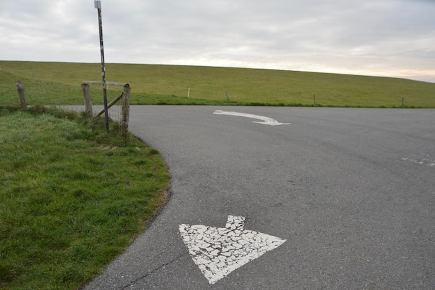 Pfeilsymbol auf der Straße gegen den Himmel