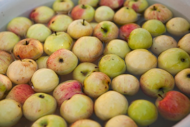 Äpfel in der Schüssel mit Wasser reinigen