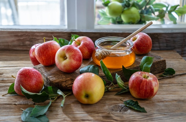 Äpfel mit Honigblättern auf dem Holztisch