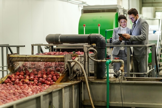 Äpfel und Managementbesuche Geschäftsleute im Anzug in einer Apfelfabrik