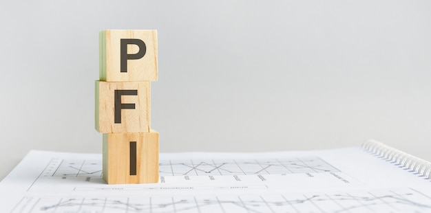 Pfi - sigla de private finance initiative, blocos de madeira, fundo cinza de conceito de negócio, documento financeiro.