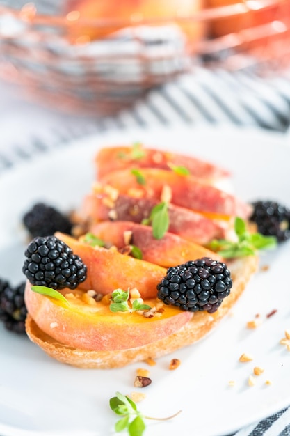 Pfirsich-Ricotta-Toast, garniert mit Brombeeren auf einem weißen Teller.