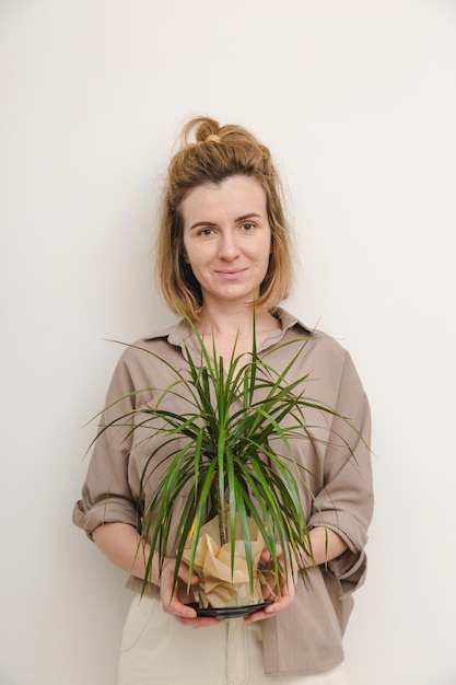 Pflanzenliebhaberfrau, die grünen Dracaena-Topf hält