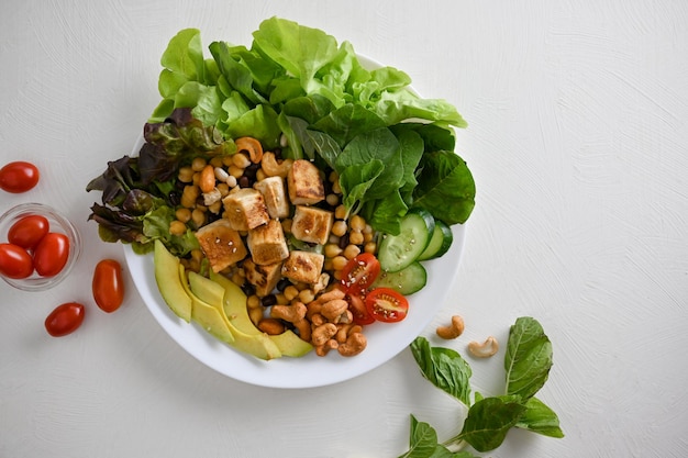 Pflanzliches Lebensmittelkonzept Gegrillter Tofu mit Kichererbsennüssen und grünem Salatgemüse gemischt