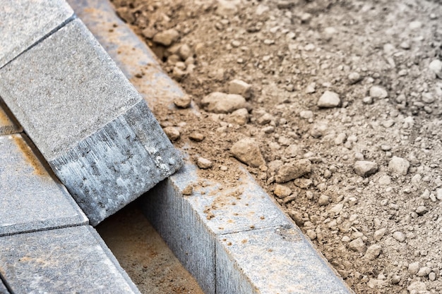 Pflasterreparaturen und Verlegung von Gehwegplatten auf der