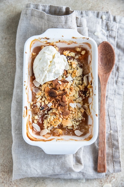 Pflaumencrumble mit Vanilleeis. Sommerknuspriges Fruchtdessert. Ansicht von oben.