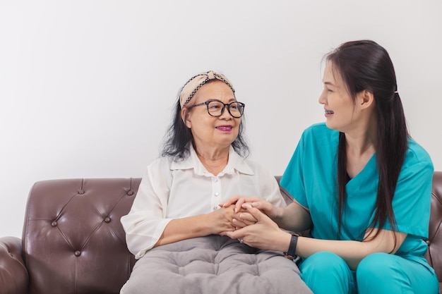 Pflegekraft mit asiatischer älterer Frau drinnen