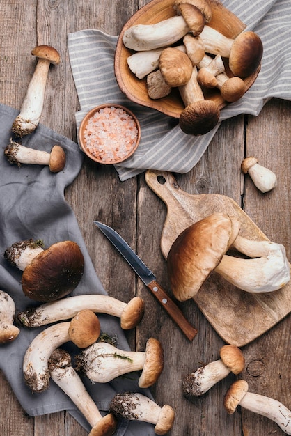 Foto pflückte porcini-pilze im korb herbsterntekonzept frische wald-boletus-pilze auf hölzern hintergrund top-ansicht kopierplatz