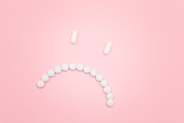 Pharma schaden trauriges Smiley-Gesicht aus weißen Pillen