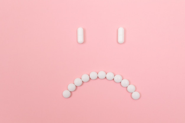 Pharma schaden trauriges Smiley-Gesicht aus weißen Pillen