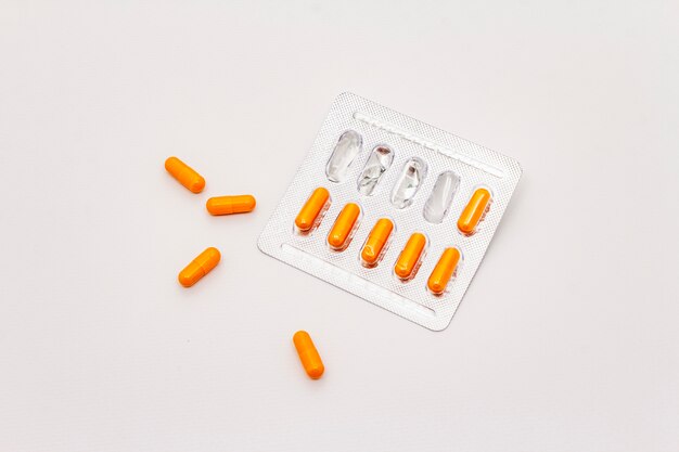 Pharmazeutische Tabletten, orange Kapseln in Blisterpackung isoliert auf weißem Hintergrund