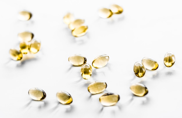 Pharmazeutisches Branding und Wissenschaftskonzept Vitamin D und goldene Omega-Pillen für eine gesunde Ernährung Ernährung Fischöl Nahrungsergänzungsmittel Pille Kapseln Gesundheitswesen und Medizin als Apothekenhintergrund