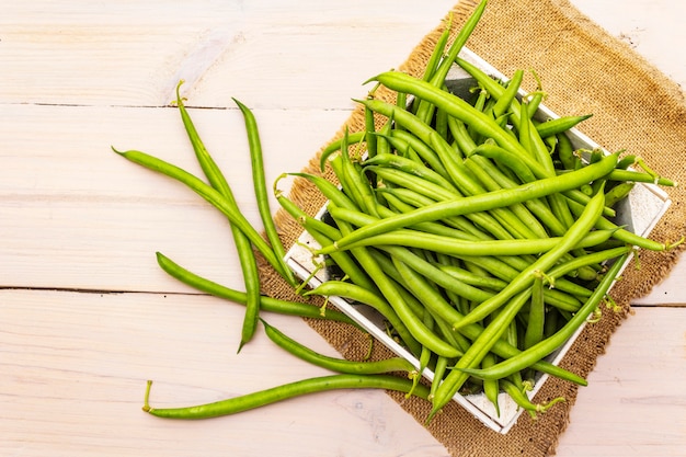 Phaseolus vulgaris, grüne gemeine Bohne oder Gartenbohne in der Holzkiste