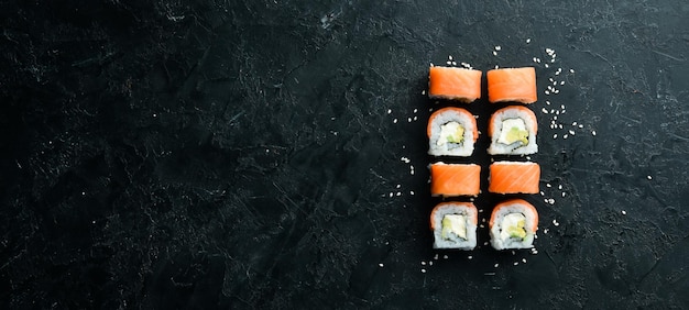 Philadelphia-Sushi-Rolle mit Lachs und Avocado Japanische traditionelle Küche Draufsicht Rustikaler Stil