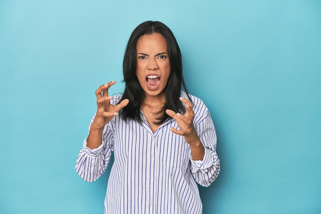 Philippinische junge Frau im blauen Studio schreit vor Wut