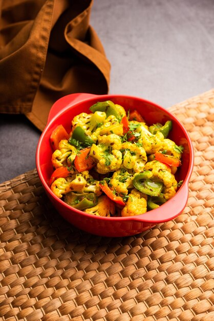 Foto phool indiano gobi shimla mirch sabji receita ou capsicum couve-flor sabzi um prato de vegetais secos saudáveis e caseiros