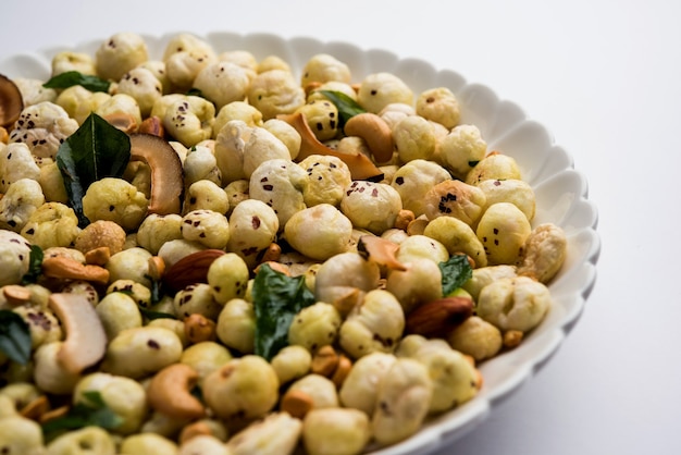 Phool Makhana Chivda es un bocadillo crujiente y saludable de la India, perfecto para la hora del té. Servido en un plato o bol. Enfoque selectivo