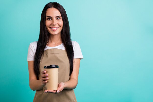 Phot oof hermosa encantadora mujer bonita bonita alegre alegre sosteniendo una taza de té desechable de papel dándole fondo de color vibrante verde azulado aislado