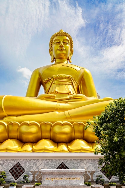 Phra Buddha Dhammakaya Thep Mongkol es una gran estatua dorada de Buda hecha de cobre tan alta como un edificio de 20 pisos de 69 metros ubicada en Wat Paknam Bhasicharoen Bangkok Tailandia en un día soleado