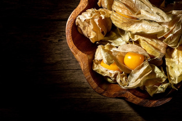 Physalis-Früchte auf einem Holztisch Süße gelbe Physalis-Beeren auf Holzhintergrund