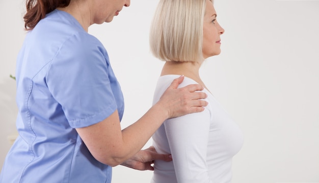 Physiotherapeut arbeitet mit Patienten mittleren Alters in der Klinik