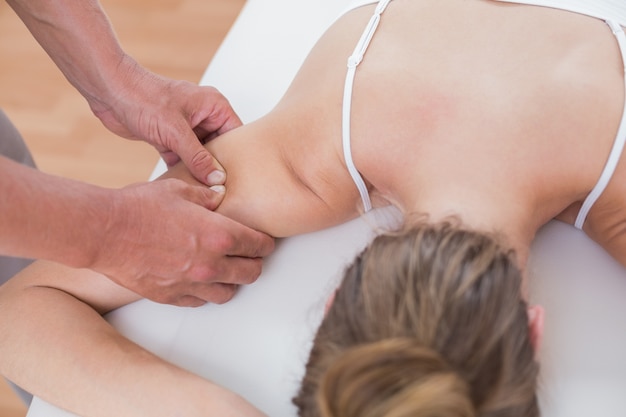 Physiotherapeut, der Armmassage zu seinem Patienten tut