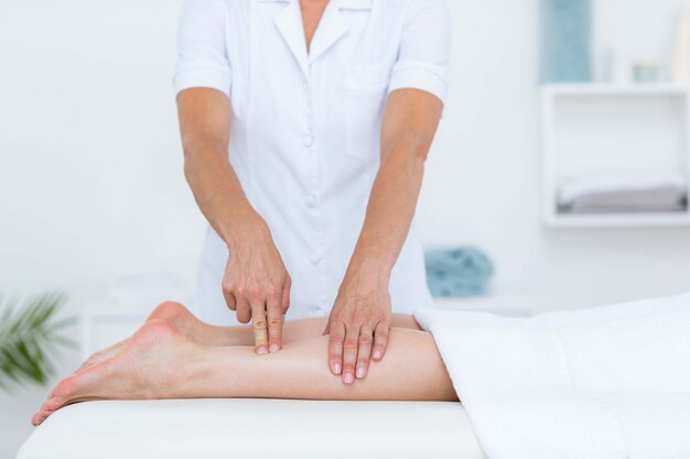 Physiotherapeut, der Beinmassage tut