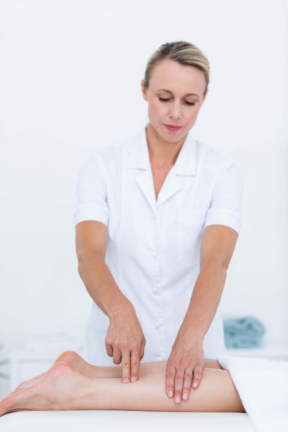 Physiotherapeut, der Beinmassage tut