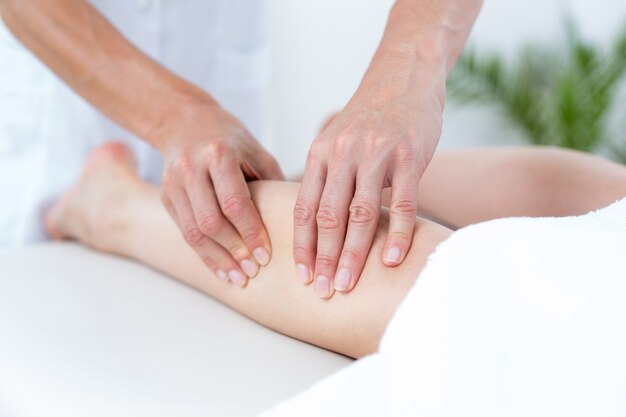 Physiotherapeut, der Beinmassage tut