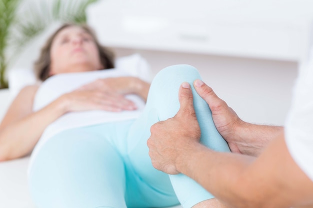 Physiotherapeut, der Beinmassage zu seinem Patienten tut