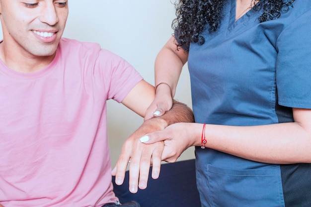 Physiotherapeut, der das Handgelenk eines jungen Patienten bewertet Nahaufnahme des Physiotherapeuten, der die Hand des Patienten rehabilitiert Physiotherapie Myofasziale Osteopathie