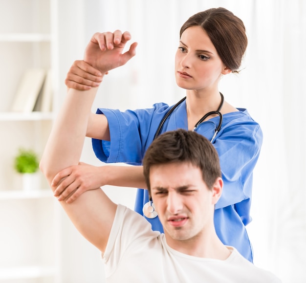 Physiotherapeut, der die Hand des männlichen Patienten massiert.