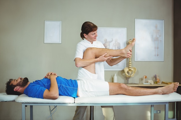 Physiotherapeut, der einem Patienten eine Fußmassage gibt