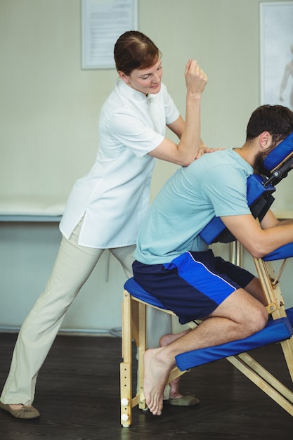 Physiotherapeut, der einem Patienten eine Rückenmassage gibt