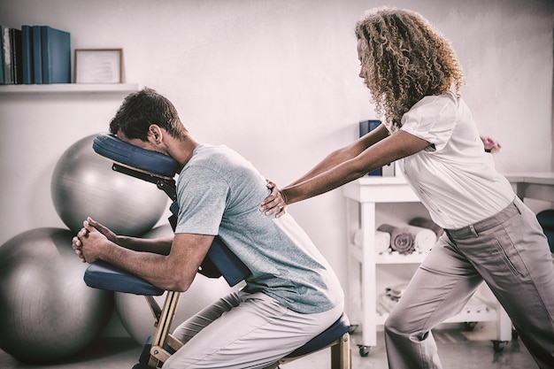 Physiotherapeut, der einem Patienten Rückenmassage gibt