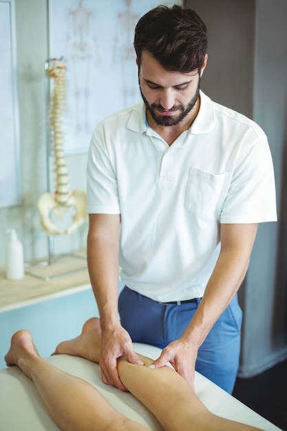 Physiotherapeut, der einer Frau Beinmassage gibt