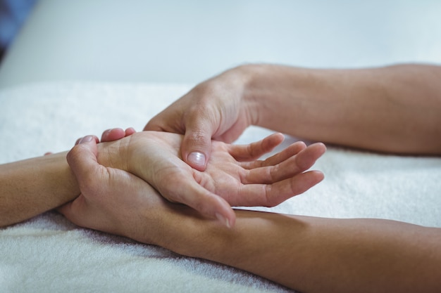 Physiotherapeut, der einer Frau Handmassage gibt