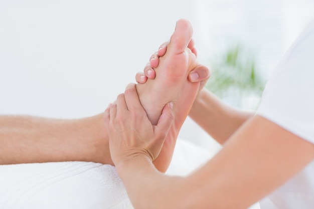 Physiotherapeut, der Fußmassage tut