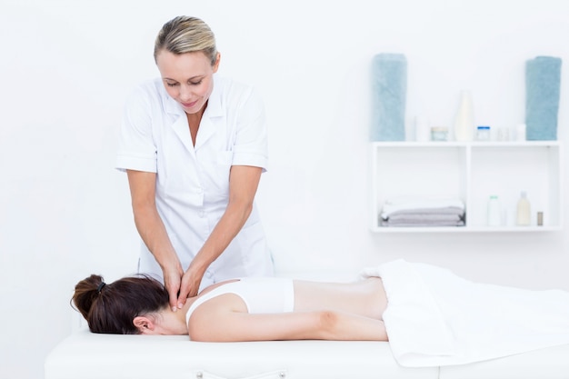 Physiotherapeut, der Halsmassage tut