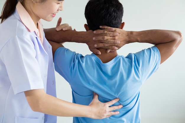 Physiotherapeut, der Heilbehandlung auf dem Rücken des Mannes tut.