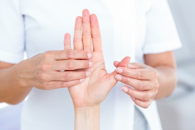 Physiotherapeut, der ihre Patientenhand überprüft